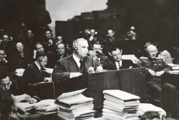 Thomas J Dodd stands at a podium during the Nurembourgh Trials.