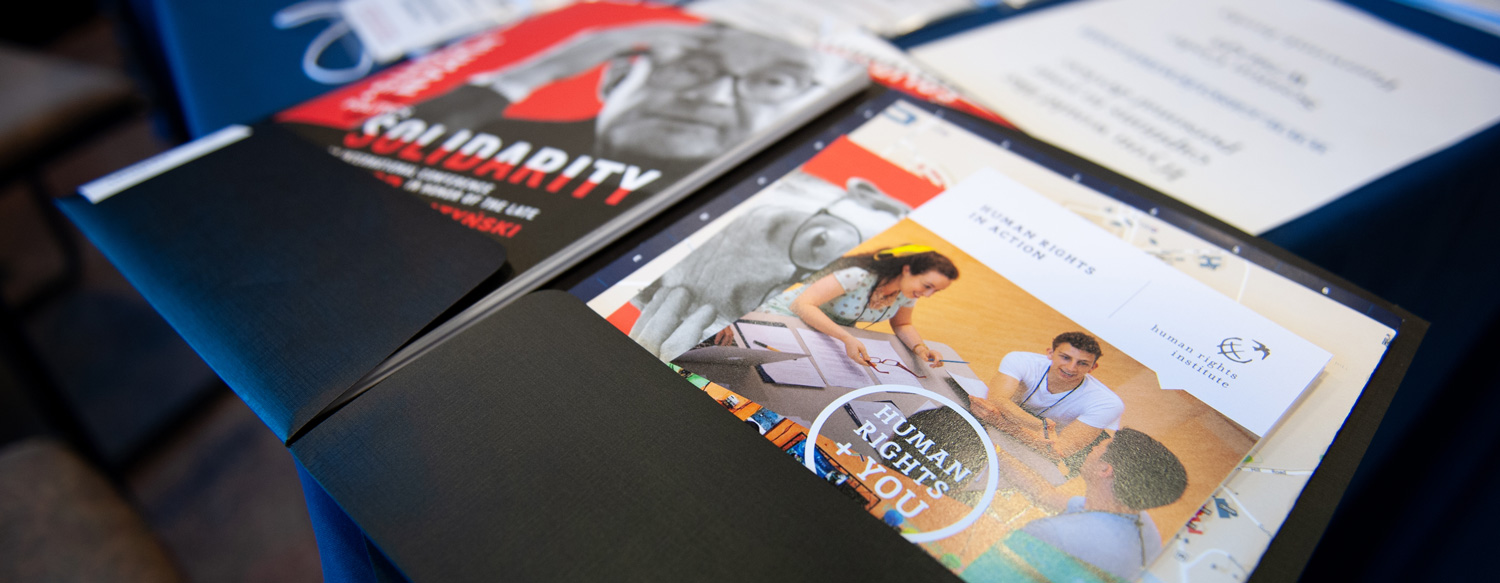 Black folder with communication and promotional printed materials.