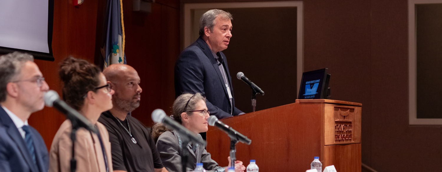 James Waller, the director of the Dodd Human Rights Impact Programs stand at the podium of the Konover Auditorium in The Dodd Center for Human Rights during a panel discussion. 