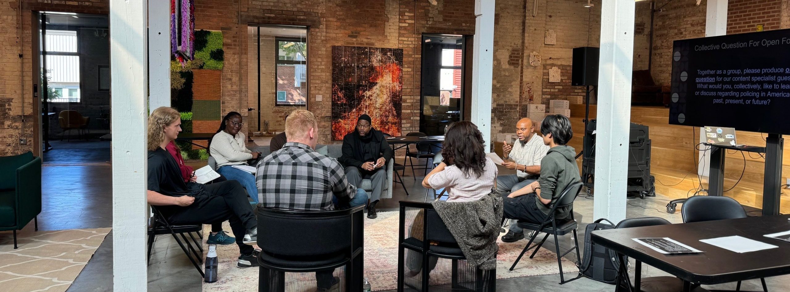 A group of people sit in a circle during a Democracy and Dialogues workshop.